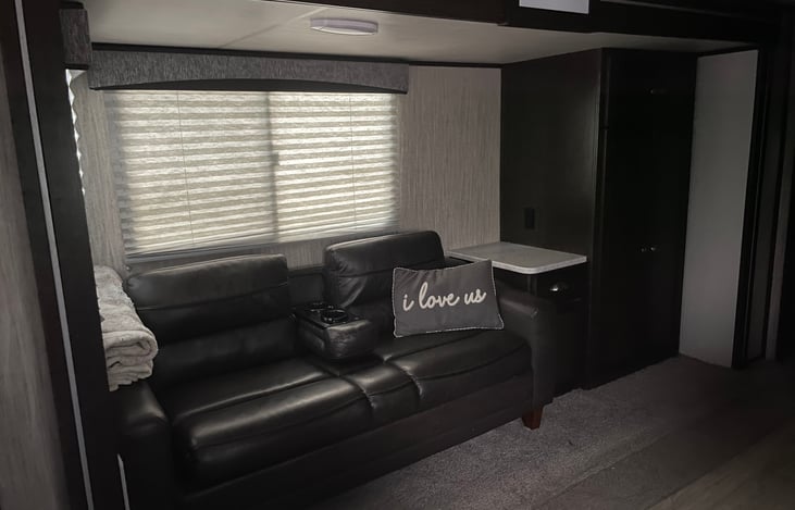 Nice couch with cup holders that can fold up. This couch pulls out into a full sized bed. There’s a side table and two big closets for clothing and more storage!