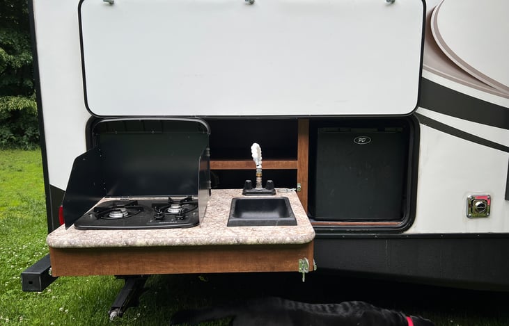 grab a cold beverage from the outdoor fridge while cooking with the outdoor kitchen