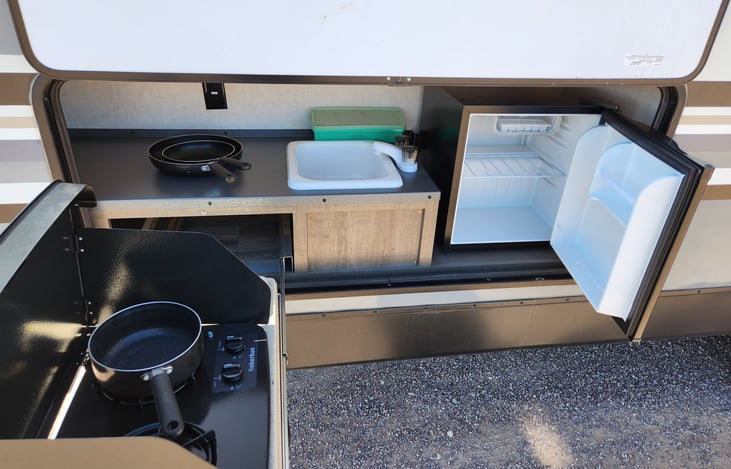 Outdoor kitchen includes, 2 burner stove, refrigerator,sink, power outlets, pots and pans, and lighting