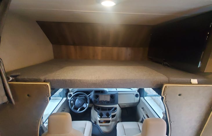 Overhead sleeping/storage area w/TV.