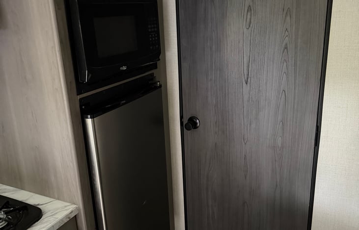 Microwave, refrigerator and bathroom door
