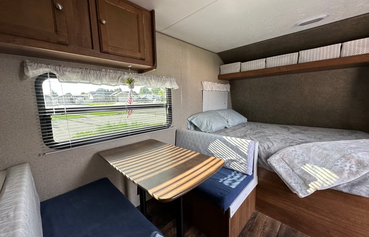 Enjoy your meals at this cozy dinette table where you can look out of the large window to see the beautiful views as you camp. The window lets in lots of natural light.