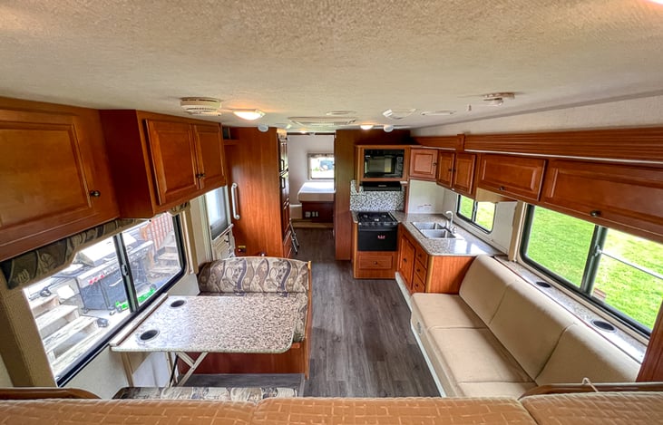 Front bed view of a leveled, opened RV.  Look at the massive space two slideouts create once you arrive to your dream destination!  Our family of 6 operates in comfort for weeks on end.