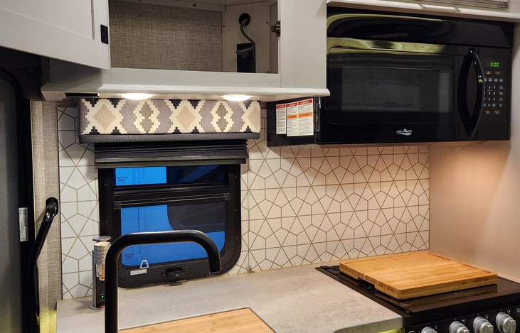 Pop-up charging station with 110 outlet and USB plugs and recessed stainless steel double sinks with cutting board covers