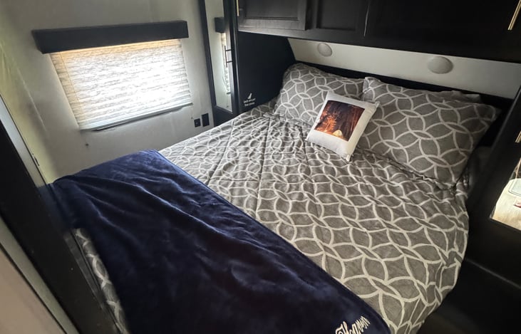 14. Private Master Bedroom
Private master bedroom with a comfortable upgraded queen mattress, quality bedding, overhead storage, and natural light.