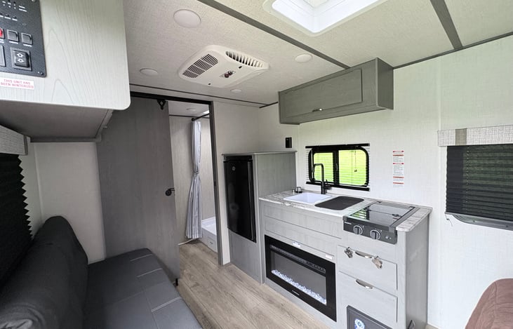 Fully equipped kitchen featuring a sink, stovetop, refrigerator, and storage—perfect for cooking meals or enjoying morning coffee with a view. Electric heater helps keep you cozy. Perfect getaway