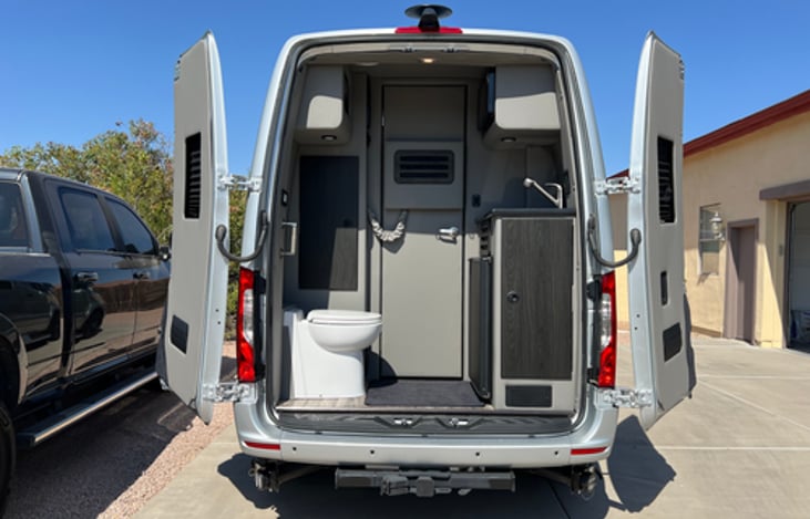 Rear bathroom with toilet, sink, microwave and mini refrigerator.