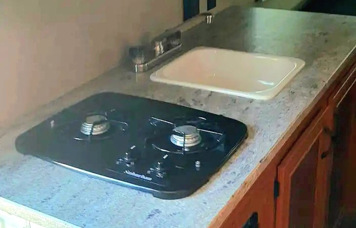 Two-burner stovetop and kitchen sink.