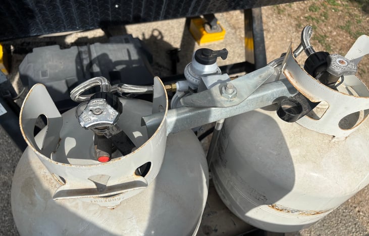 Dual 30-lb propane tanks provide reliable fuel for hot water, cooking, and refrigerator operation while traveling.