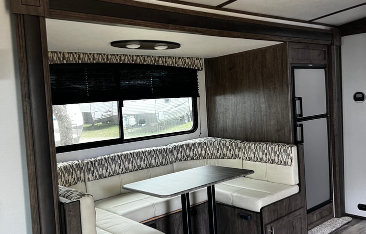 Seating area for 5, with 10.2 cubic refrigerator. LED lights surrounded by large windows.  This same dinette is turned into a bed to sleep two people.  It is the same size as a full bed.