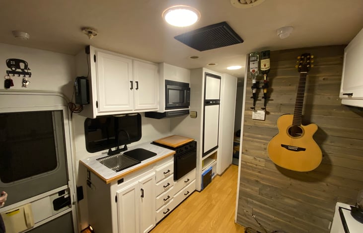 Remodeled living area with a foldable table for four, a nice Acoustic Guitar, Classic Record Player with few old country records, Whisky Holder on the wall to fit your style! Cigar holder, USC