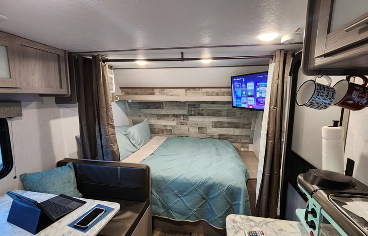 Queen Bed with linens and 4 pillows with privacy curtain.