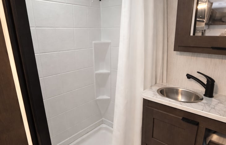 Bathroom: Shower with sky light to ensure comfort and overhead space. Enjoy a private vanity and restroom sink.