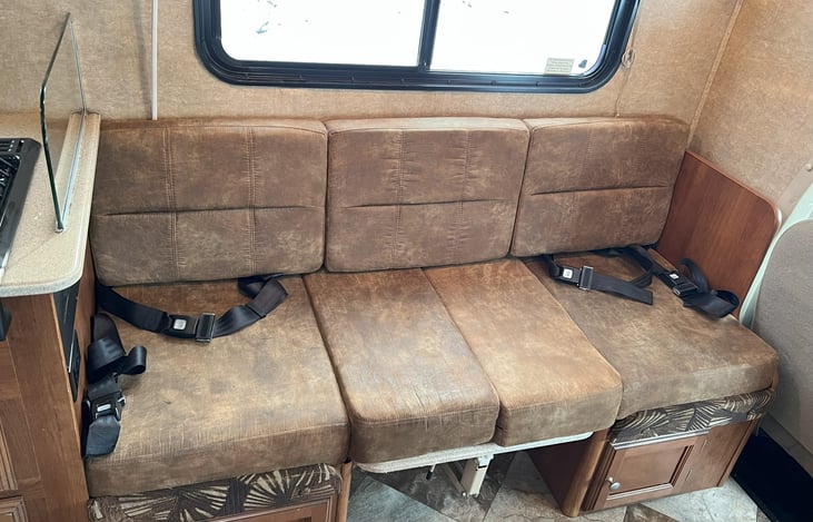 Overflow dinette/kids' table converted to bed with seatbelts and lower cabinet storage shown.