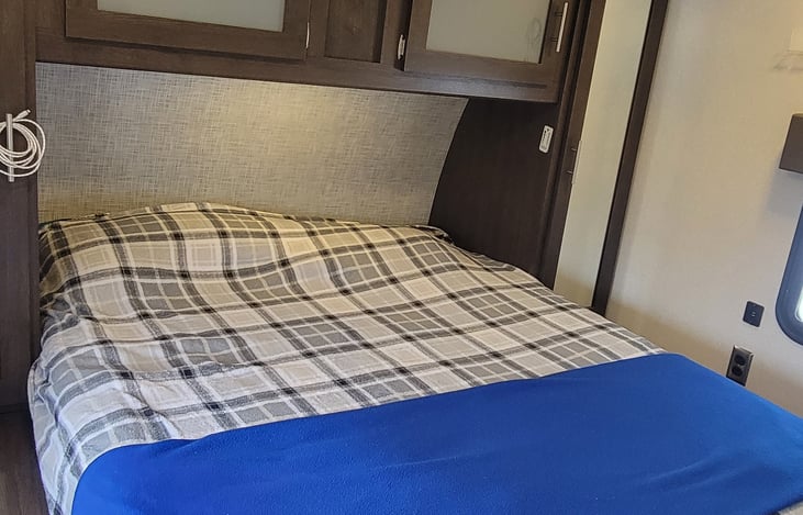 RV Queen memory foam mattress in separate bedroom. Overhead storage and bedside closets.