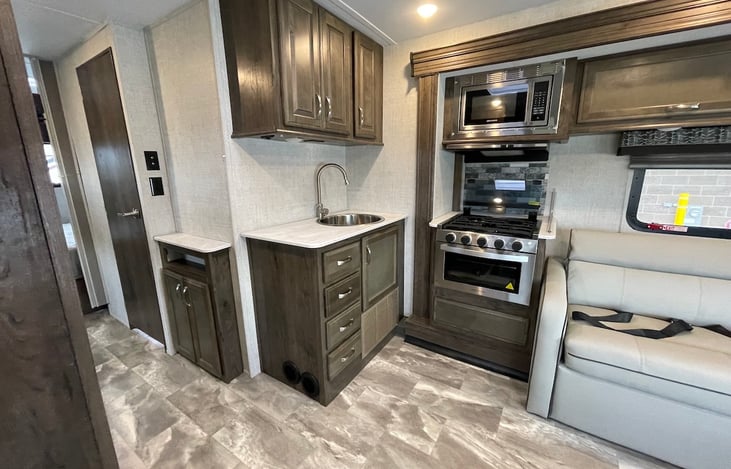 kitchen area with microwave, toaster, electic tea kettle inside and coffe maker inside cabinets.