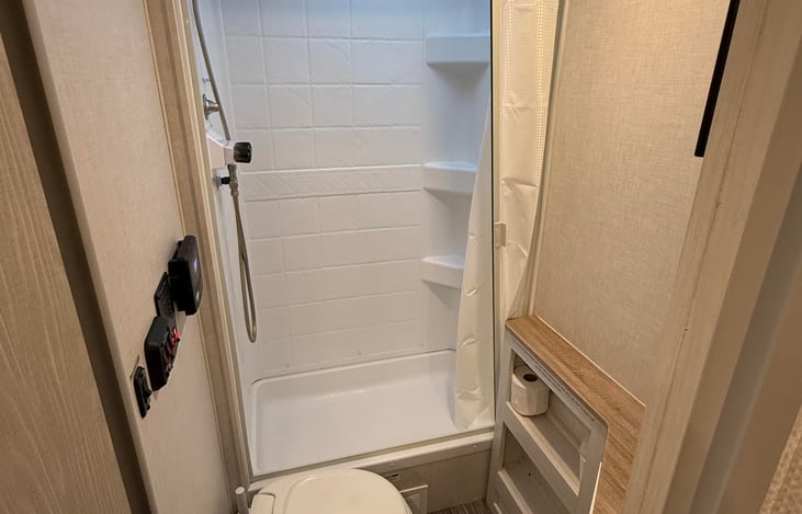 Full-featured vented bathroom. Toilet, shower, sink, mirror, and medicine cabinet.
