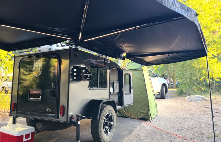 The awning has lights that will illuminate your campsite nicely at night. We provide a battery bank to run them and you can charge it in your camper through the battery.