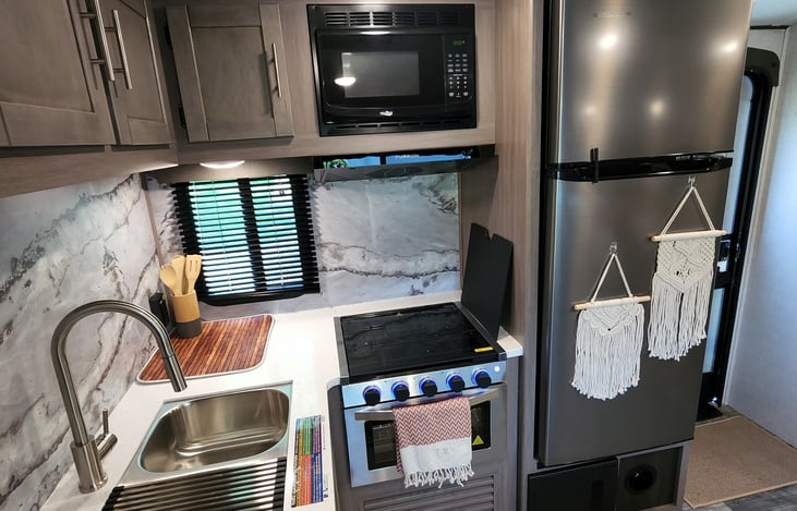 Full size kitchen sink, stove, microwave, and huge fridge.