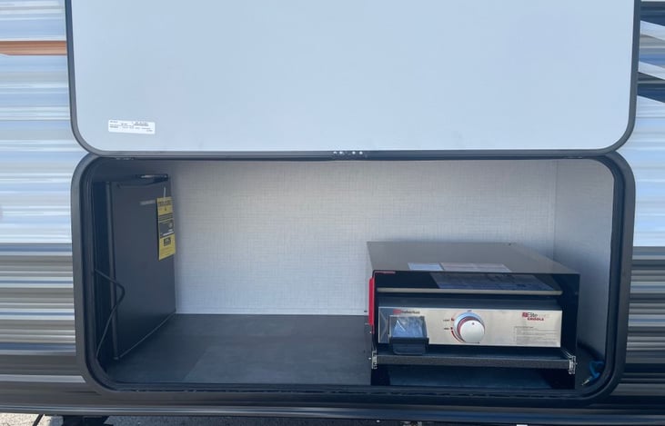 Outdoor kitchen with griddle and mini-fridge