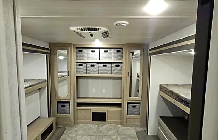 Read bedroom area w/ mirrors, closets, shelves, and storage bins.