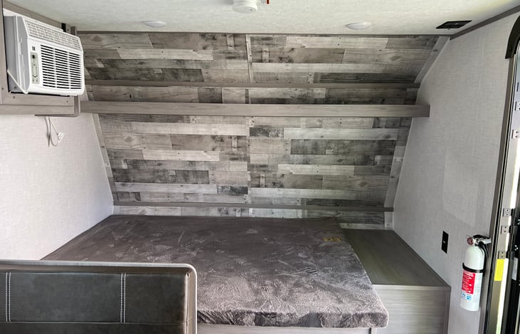 Queen bed with storage shelf above, there is also a storage compartment under the bed!