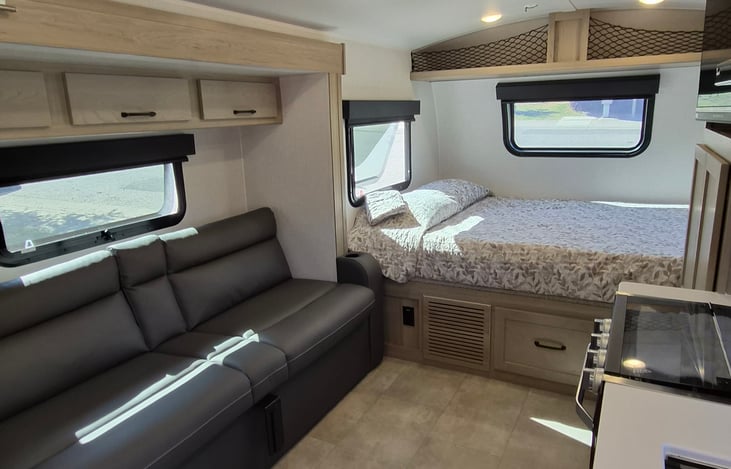 Queen bed with storage above and drawer below. Couch pulls out to full size bed.   All windows have black out pull down covers.