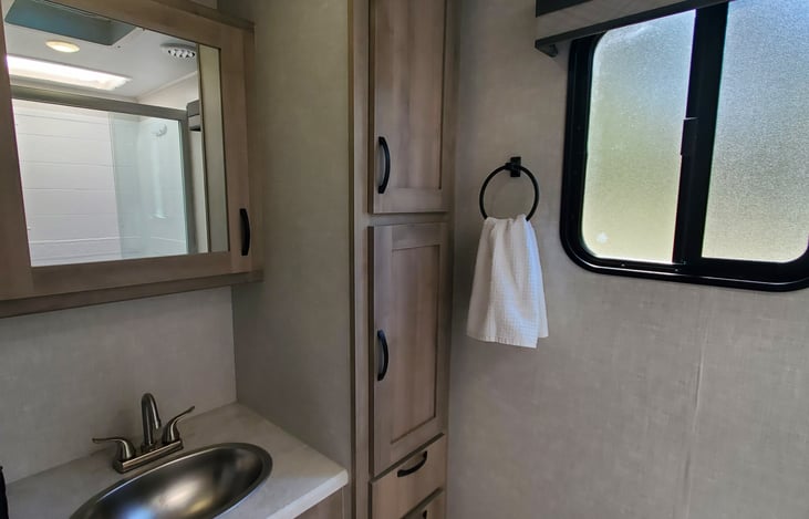 Spacious bathroom with plenty of room for all your toiletries. Window and vent for air circulation during showers.