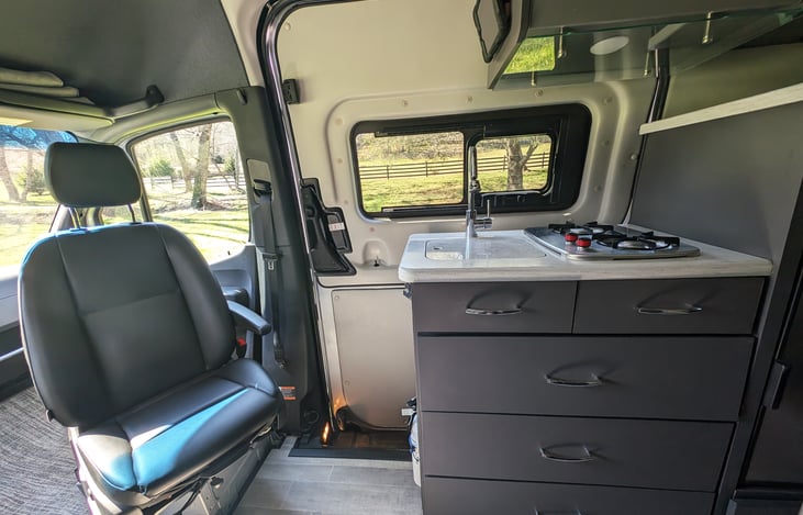 Well equipped kitchenette with gas stove top and a microwave. Chairs swivel around for more seating options.