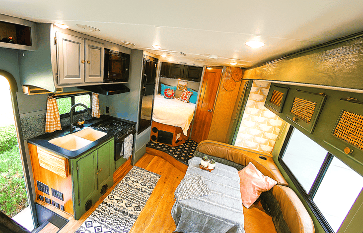Charming RV interior with full kitchen and sleeping space — ideal for family motorhome rentals.