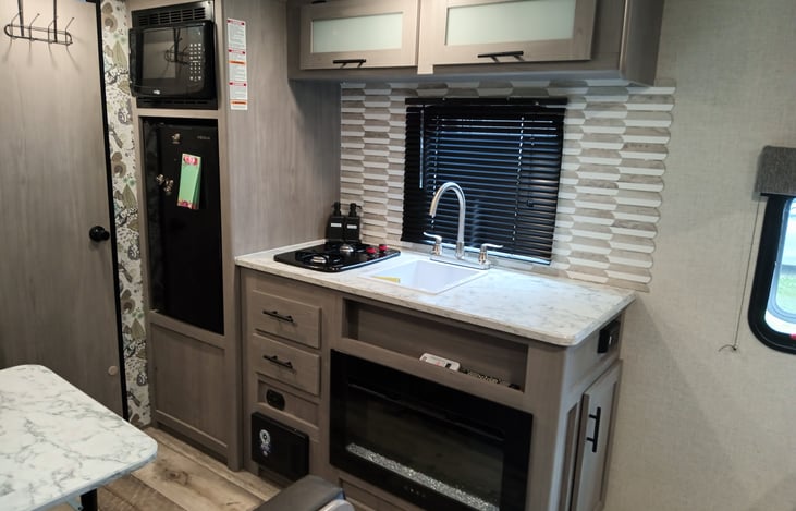 Kitchen with two stove burner, microwave, fridge and a gorgeous fireplace. Everything that you need!