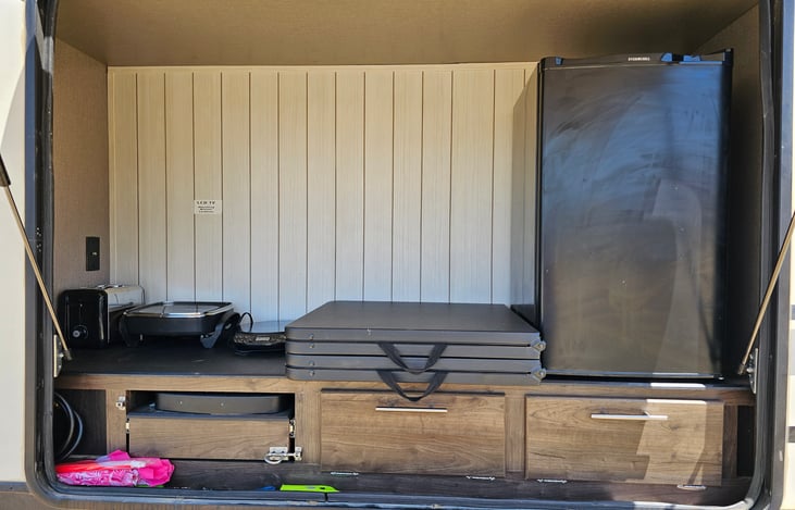 Outdoor Kitchen with George Foreman grill, tables, food nets, and fridge