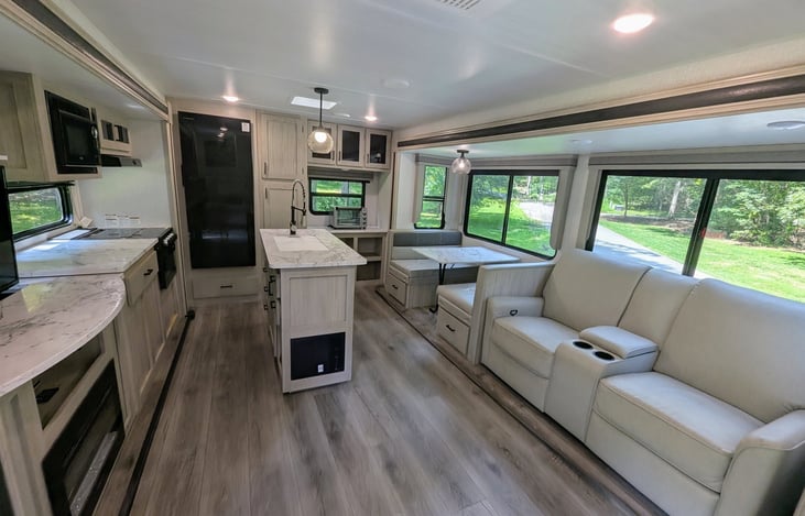 Bright, spacious and luxurious interior. Well-equipped kitchen with island and large refrigerator. Telescoping TV with fireplace. Ample storage. Cozy recliners. Large windows for natural light.