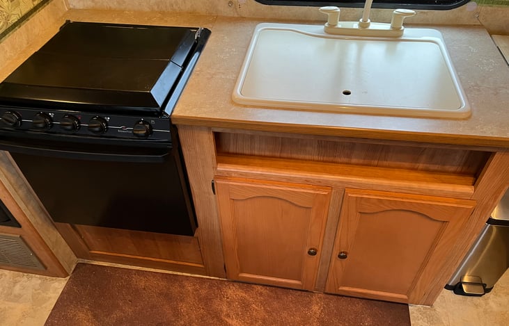 Kitchen, sink has cover for when not in use.