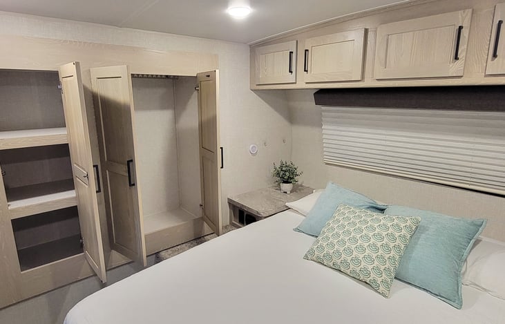 Queen bed with full size hanging closet and shelves.
