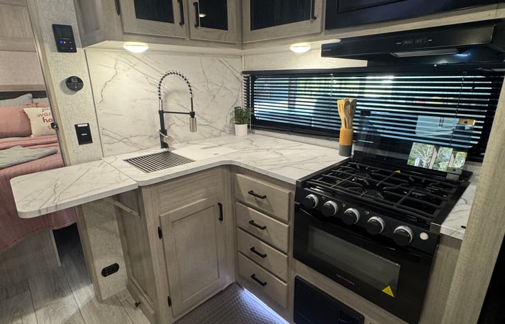 Kitchen- includes extended counter space, large sink, gas stove with 3 burners and a small oven.