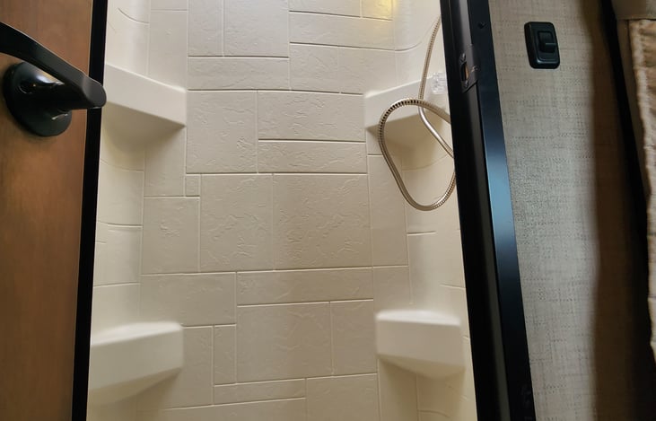 The shower has shelving and a sky light.