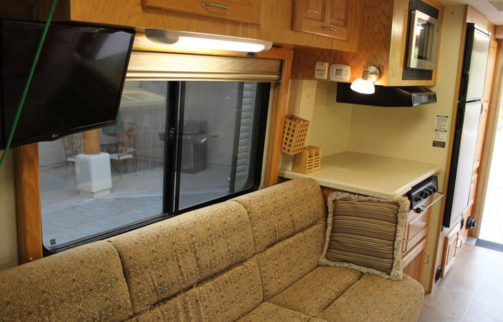 Couch with spacious storage cabinets above / 
3 burner stove / large refrig/freezer