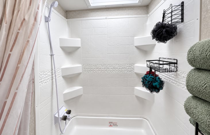 Large shower with overhead skylight.