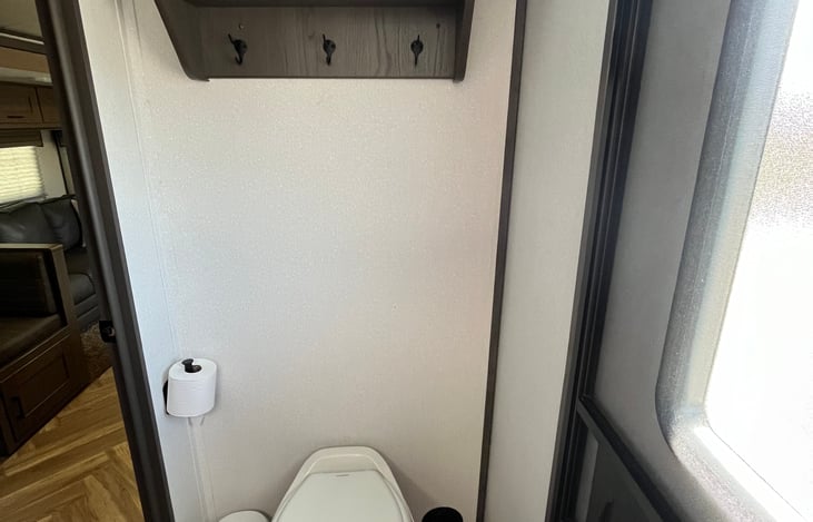 Toilet with storage shelves above.