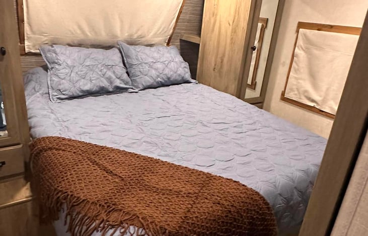 Master bedroom featuring an upgraded, comfortable queen-size bed and a private door for added privacy.