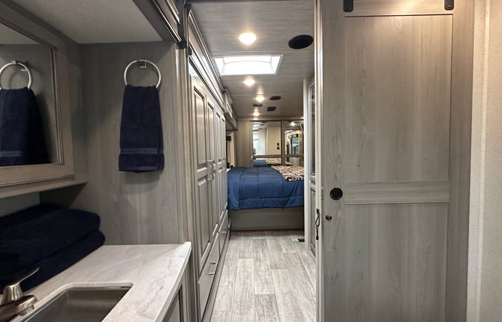 Barn door separates bathroom from bedroom for additional privacy.