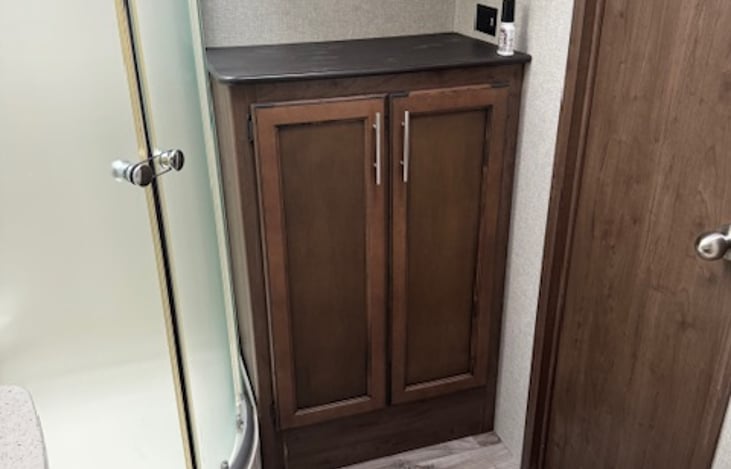 Bathroom has lower and upper storage, and a large shower. Bath linen provided. Ceramic foot flush toilet.