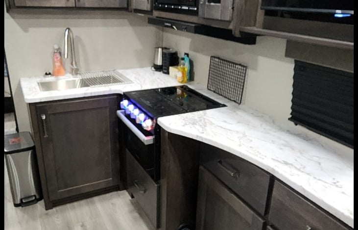 View of kitchen looking toward bathroom. Roku TV for wifi or Hotspot streaming. TV is also capable of local air broadcasted channels.