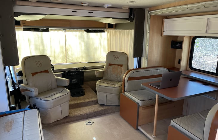 Living room. Note the twin bed that comes down above the captain chairs. Also, note the slot for an optional small round table, on the floor between the captains chairs.