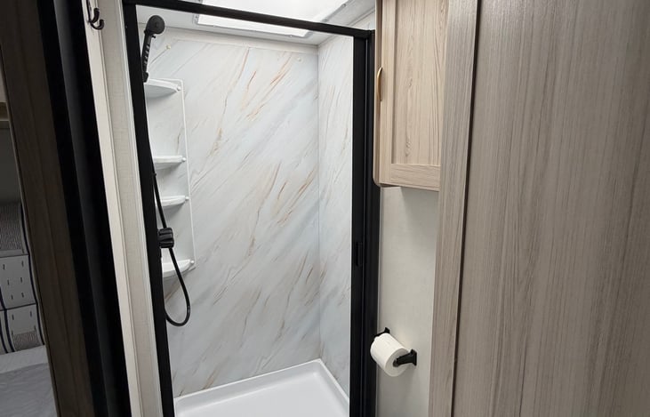 Shower and sinks are connected to a tankless water heater. Includes RV TP, Soap, and Hand Soap.