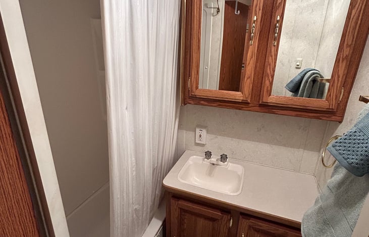 Full bathroom with shower, toilet and sink. Hot and cold running water.