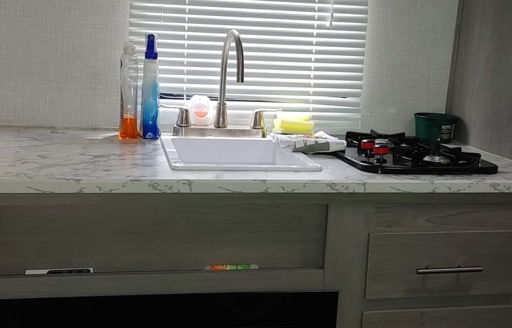 Sink and gas burners. Storage drawers and cupboards with dishes, silverware, plasticware, screwdriver, dish liquid and cleaners, bug spray, etc.