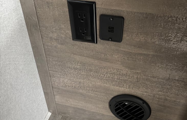 Bedside table with AC/Heat vent, outlets, and USB ports for convenience.