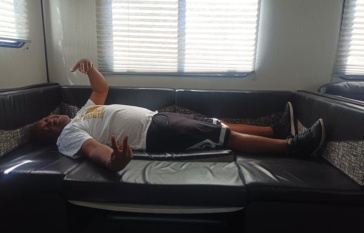 Dining Booth converted to bed. This is me 5'11".. highlighting that I plus another adult can sleep here comfortably. Very comfortable bed.